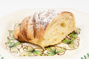 Half croissant in a dish on the table