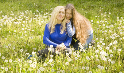 Fototapeta premium Mother and daughter with white dandelions