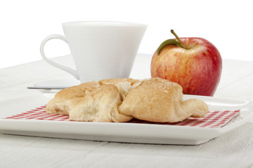 almond croissant in plate with apple and cup