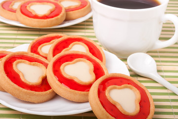 cookies with jelly and cup of coffee on bamboo napkin