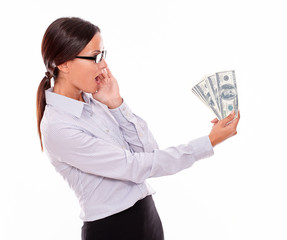 Surprised brunette businesswoman looking at money