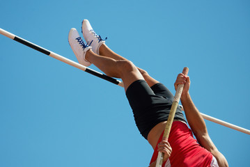 Athlete pole vault with a blue sky