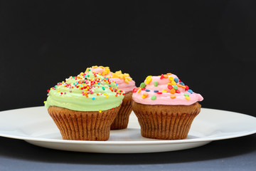 Sweet chocolate cupcake. Close up of chocolate cupcake. Muffins. Fresh delicious homemade cupcakes. Chocolate cupcakes with chocolate frosting on top with sugar sprinkles. Shallow depth of field.