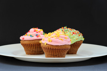 Sweet chocolate cupcake. Close up of chocolate cupcake. Muffins. Fresh delicious homemade cupcakes. Chocolate cupcakes with chocolate frosting on top with sugar sprinkles. Shallow depth of field.