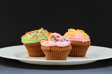 Sweet chocolate cupcake. Close up of chocolate cupcake. Muffins. Fresh delicious homemade cupcakes. Chocolate cupcakes with chocolate frosting on top with sugar sprinkles. Shallow depth of field.