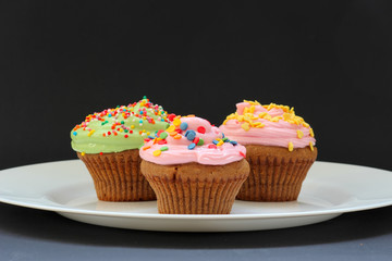 Sweet chocolate cupcake. Close up of chocolate cupcake. Muffins. Fresh delicious homemade cupcakes. Chocolate cupcakes with chocolate frosting on top with sugar sprinkles. Shallow depth of field.