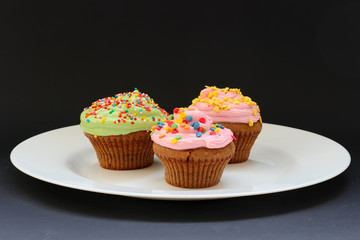 Sweet chocolate cupcake. Close up of chocolate cupcake. Muffins. Fresh delicious homemade cupcakes. Chocolate cupcakes with chocolate frosting on top with sugar sprinkles. Shallow depth of field.