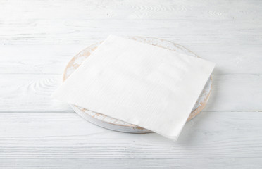 White napkin on a white wooden table. Top view
