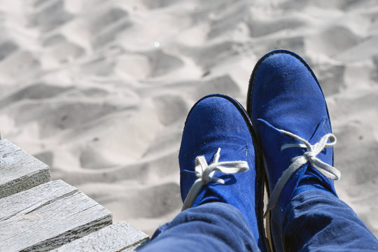 Blue suede shoes on the sand