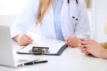 Fototapeta premium Doctor and patient are discussing something, just hands at the table