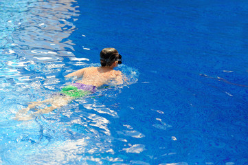 Child swimming in outdoor pool