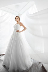 Fototapeta premium Brides beauty. Young woman in wedding dress indoors