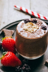 Photo of fresh Made Chocolate Banana Smoothie on a wooden table with coffee and spices. Selective focus. Milkshake. Protein diet. Healthy food concept. 