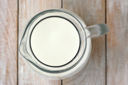 White milk the jug on the wooden background