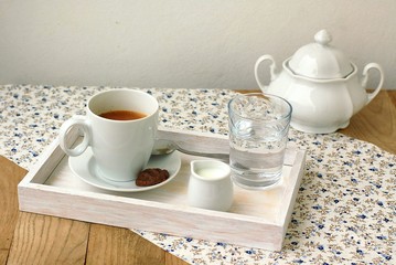 Espresso in the cup with milk, biscuit and sugar basin