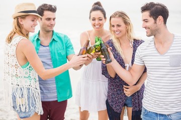 Group of friends toasting beer bottles on the beach