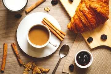 Breakfast with coffee and croissants on wooden table