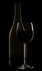 Wine glass and bottle on black background rim lighting