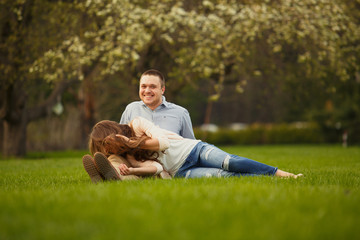 Happy Smiling Couple Relaxing on Green Grass.Park