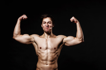 Fototapeta na wymiar Handsome power athletic man with dumbbell confidently looking forward. Strong bodybuilder with six pack, perfect abs, shoulders, biceps, triceps and chest. Great fitness body. Ideal for commercial 