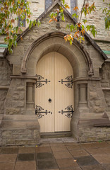 Fototapeta na wymiar Church cream double door set in stone archway