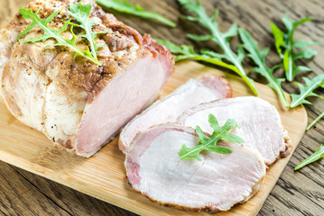 Baked meat with fresh rocket salad on the wooden board