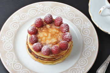round cake with raspberries and cup of tea