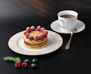 round cake with raspberries and cup of tea