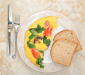 omelet with spinach, tomatoes and mushrooms on round plate