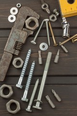 Disorder in the tool. Preparing for home treatment. Various tools, screws and nuts on a wooden background. Tool repairman.
