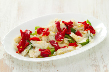 fish salad on white dish on white wooden background