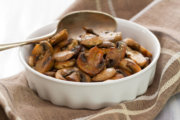 fried mushrooms on white dish on white wooden background