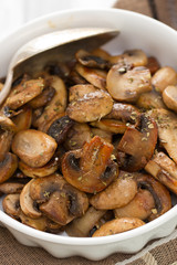 fried mushrooms on white dish on brown wooden background
