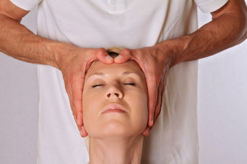 Reiki chakra balancing treatment.Chiropractic, osteopathy, acupressure. Woman enjoying head massage.   Alternative medicine,