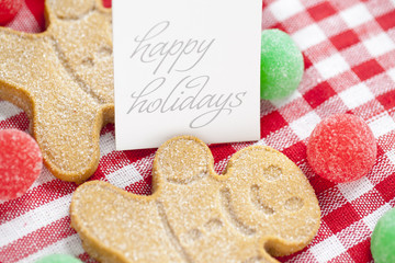 close-up shot of happy holidays tag with gingerbread candies.