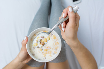 Woman eating cereals in bed