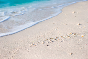 Fototapeta na wymiar Holidays summer concept. The word summer written in the sand