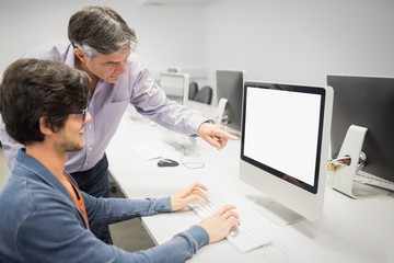 Computer teacher assisting a student