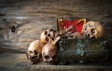 skull and box on wood background , still life