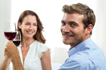 Smiling couple toasting wineglasses