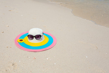 Obraz premium Colorful hat with glasses on the beach
