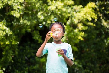 A little boy blowing bubbles