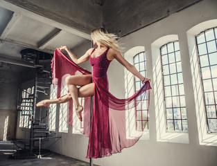 Sensual blond female pole dancing.