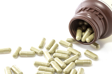 Herbal medicine capsules on white background.
