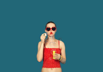 Pretty Fashion Woman doing soap bubbles in Studio on Blue Background isolated