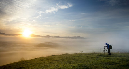 Obraz na płótnie Canvas photographer on the hill with sun in the morning