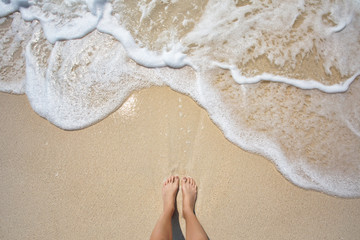 Vacation on ocean beach, feet on sea sand - obrazy, fototapety, plakaty