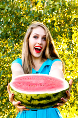 Beautiful blonde girl holding a sliced watermelon