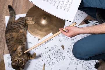 Naklejka premium Drums conceptual image. Picture of man with stick and music notes. Background - cymbals, notes and cat