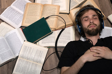 Young attractive man listening to books with headphones